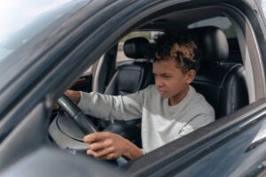 Jongeman die rijlessen neemt in Eindhoven, met instructeur en auto